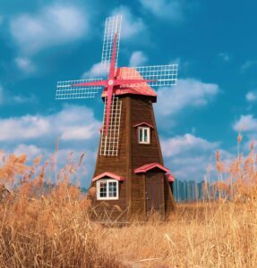 Windmill in a field at sunset