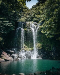 Waterfall surrounded by lush greenery in Jeju Island